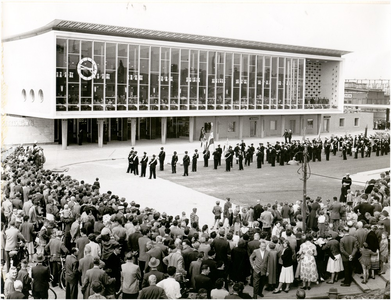 137009 Toeschouwers tijdens het optreden van de harmonie voor het station, 10-08-1956