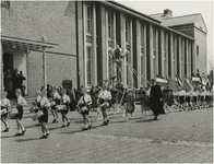 197406 Optocht van schooljeugd voor het stadhuis. Bij de hoofdingang bekijkt onder andere burgemeester Kolfschoten het ...