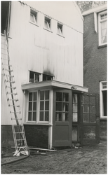 197492 De hoofdingang van het noodgebouw met rechts de verbinding van het stenen gebouw. De eerste aanvalsstralen werd ...