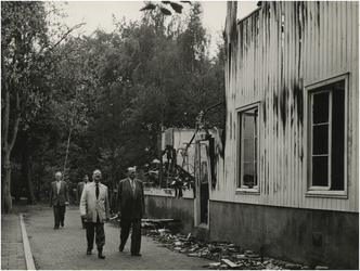 197500 Het bekijken van de afgebrande vleugel door burgemeester Van Rooy (links vooraan) met schuin achter hem ...