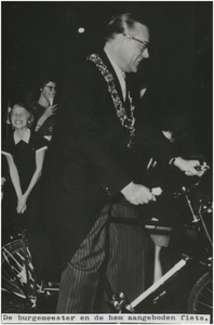 197714 Burgemeester Witte op een hem aangeboden fiets. Op de achtergrond zijn dochters, 28-10-1959