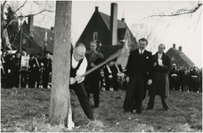 197729 Het omhakken van een boom door wethouder H.M. van Lieshout op de plaats van het nieuwe GG en GD gebouw. Op de ...