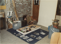 254903 Foto’s op de vloer, koffers, visnet , melkbus en andere spulletjes, 04-1960