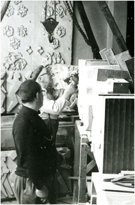 253868 Het beeldhouwen aan het relief Ik kom, ik ga door Willy Mignot (vooraan, met donkere trui), 1956