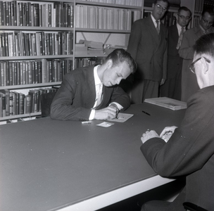 254907 Student Hans Wijffels ondertekent als allereerste student aan de TH Eindhoven zijn collegekaart, 09-1957