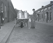 254952 Hond ligt voor volgeladen kar met melkbussen (melksteupen) , 04-1949