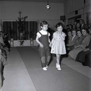 255023 Twee kleine meisjes op de catwalk, toeschouwers, 1955