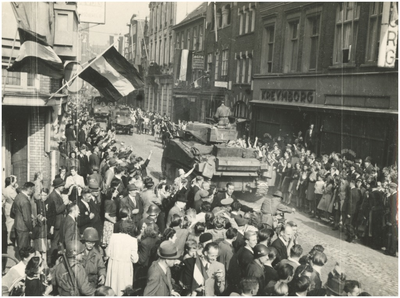 139898 Het rijden van een geallieerde tank door de feestvierende bevolking in de Rechtestraat, ter hoogte van ...