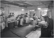 139960 Het persen van textiel door medewerksters van de strijkafdeling, 1960
