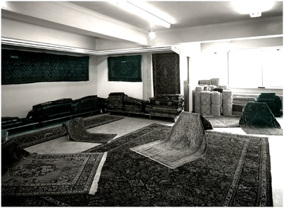 139991 Het etaleren van Perzische tapijten in de showroom van Perez, 05-1961