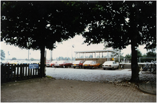 106086 Stationsplein. Parkeerplaats van de Nederlandse Spoorwegen. Op de achtergrond het wachthuisje op het perron van ...