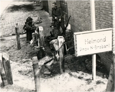 109926 Engelse militairen bij een schuttersputje aan de Mierloseweg, voor de houthandel van Johan Raaijmakers. Foto ...