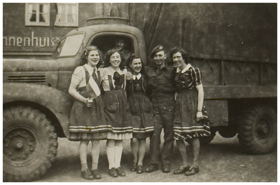 110047 Enkele meisjes met Britse militairen voor een legervoertuig voor meubelhandel 't Binnenhuis aan de Markt. Links ...