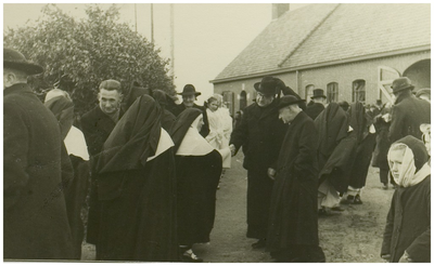 111499 Aankomst van de zusters van Bethanie op Binderen.Pastoor van Laarhoven drukt een der zusters de hand nabij de ...