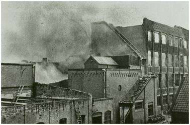 113120 Kanaaldijk N.W. 29 / Trambrugweg. J.A. Carp's Garenfabriek, van opzij gezien, tijdens de brand op 16 december ...