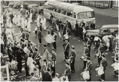 118527 Helmonds Muziek Corps, drumband, tijdens een drumbandconcours te Helmond in 1959. Op de achtergrond in witte ...