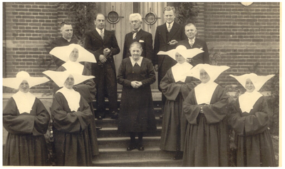 45168 Het vieren van jubileum Gon Driesen, huishoudster van de pastoor, Budel-Dorplein: foto aan achterzijde van de ...