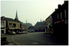45251 Markt Budel: Diverse winkelpanden, op achtergrond de kerk en het voormalig gemeentehuis, 2000