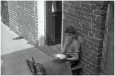 47589 Straatmuzikant spelen (zoon van kapper van der Wielen), Budel, circa 1960