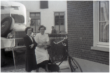 47594 Poseren voor woning met op achtergrond café Nouwen, Budel, 1960