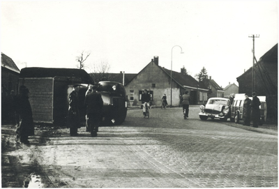 132278 Ongeval op de Dorpstraat, gedeukte auto, toeschouwers, 08-09-1957