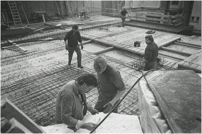 846 Het maken van een betonbewapening met op de voorgrond bouwvakkers bij de bouwtekening, 03-1992