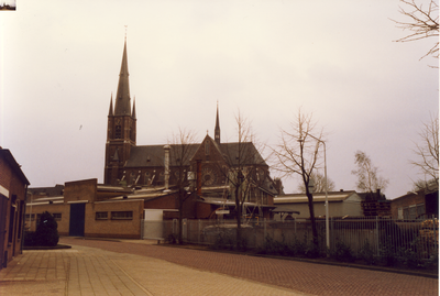 579411 Op de voorgrond klokkengieterij Eysbouts en op de achtergrond de kerk Heilige Maria Presentatie, februari 1990