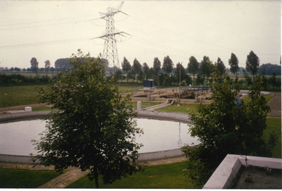 580626 Rioolwaterzuiveringsinstallatie aan de Waardjesweg, met op de achtergrond een hoogspanningsmast, 1970-1980