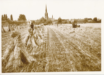 576474 Het koren wordt gemaaid en in schoven geplaatst. Met de kerk op de achtergrond, 1930