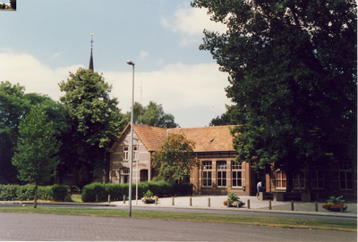 577180 Vooraanzicht van Oude Antoniusschool achter grote bomen, 1989