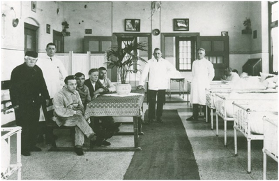 188665 Personeel en clienten in de binnentuin van een pavilljoen, met in het wit dhr. M. v.d. Langen, 1920 - 1925
