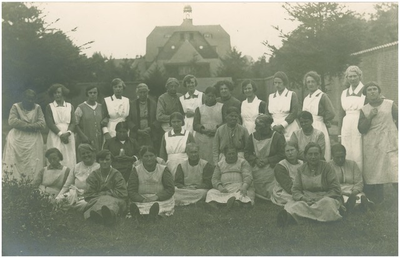 188669 Verpleegsters en clienten in de binnentuin CD. Op de achtergrond de instellingskerk, 1927
