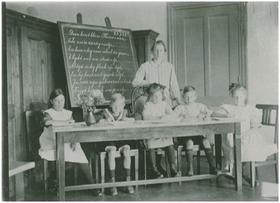 188671 Onderwijzeres met haar leerlingen van de school voor kinderen van personeelsleden, in het hoofd gebouw, 1930