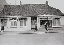 27595 Hoogstraat, met de groenten-fruit en vishandel op nr.112 en het café De Gouden Bal op nr.112a, 03-1972