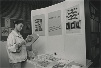 251967 Landelijke campagne voor scholing meisjes: het lezen van een informatiefolder op het stadskantoor, 1989