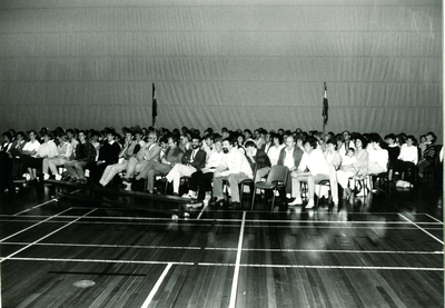 231230 Genodigden in de sportzaal, met vooraan op de bank met baard Hen Peeters, raadslid., 28-09-1985