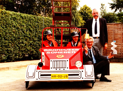231347 Deelnemende brandweerauto, met van links naar rechts: Jan Smits, Henk Rooijmans, Burgemeester Roels en staande ...