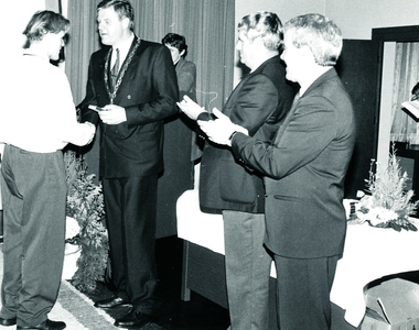 232489 Hans Deelen ontvangt de medaille van burgemeester Vos, met rechts Wethouders Wim Deenen en Jan Hendriks, 15-1-1993