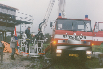 232605 Burgemeester Vos word omhoog gehesen in de bak van de brandweerkraan om de vlag te plaatsen, 22-09-1993