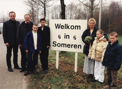 234730 Gezinsfoto van de familie Veltman bij het welkomstbord van hun nieuwe gemeente Someren, 01-04-2000