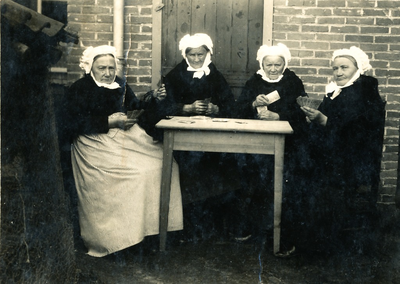 236072 Johanna Maria van Otterdijk (uiterst links) aan het kaarten, met de poffer op, 1920-1930