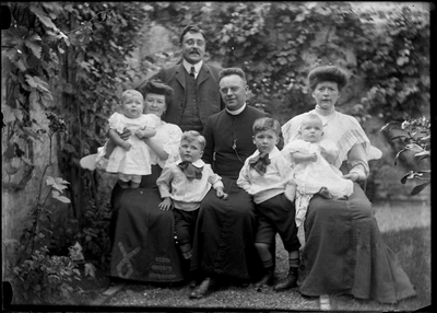 153 Familieportret; geestelijke; binnentuin, circa 1905