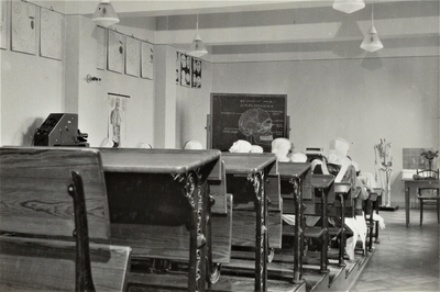 4397 kliniekklas; schoolbanken; schoolbord; skelet; wastafel; verloskundigen in opleiding; klaslokaal; les, 1953