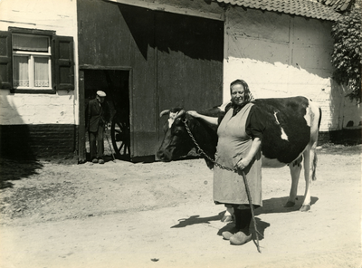 2592 Een boerin met een koe voor een witte boerderij, 1945-1961