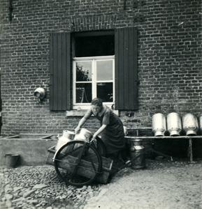 2890 Boerin plaatst melkbussen in een handkar, 1938-1939