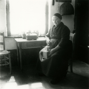 3145 Boerin in de keuken met koffiemolen, 1938-1939