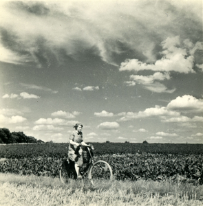 4111 Vrouw fietst langs een akker, 1938-1939