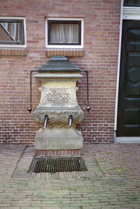  Zanstenen pomp met waterspuwers en met tekst op binnenplaats Lamme Huiningegasthuis. Opschrift: cerenoveert MDCCLXIII ...