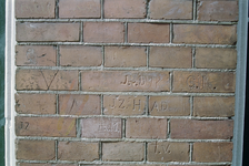  In baksteen ingekraste initialen en meisjesportretje Haddingedwarsstraat 3, Groningen 109856