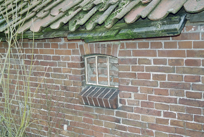  Dichtgemetseld gietijzeren stalraampje en dakrand met pannen Hogeweg 13, Dorkwerd, Groningen 106323